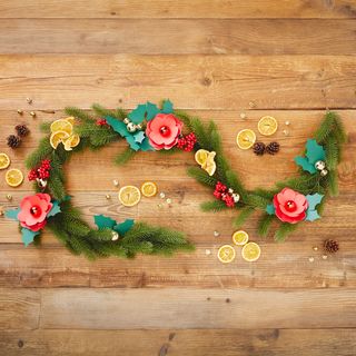 Dennenkrans met bloemen van gekleurd papier