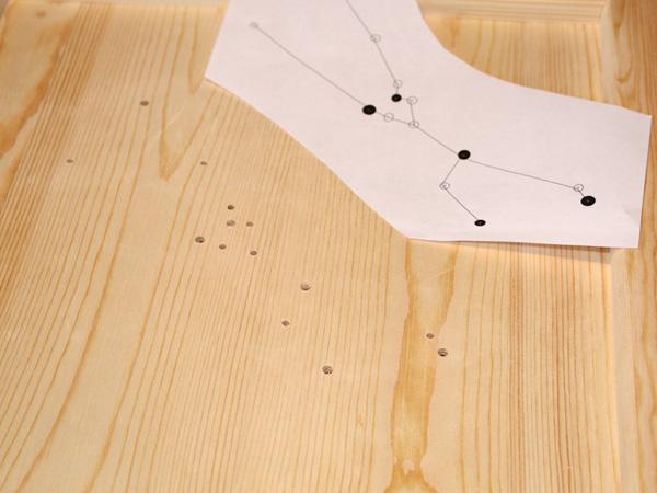 Anleitung für Lichtdekoration mit Sternzeichen: Löcher bohren Löcher für das Sternzeichen in die Holzplatte bohren